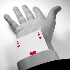 An Ace of Hearts card protruding from the end of a business person's sleeve