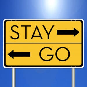Road sign with arrow pointing one way to Stay and another way to Go