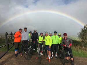Members of Fuel recruitment team taking part in a coast to coast charity cycle ride under a rainbow