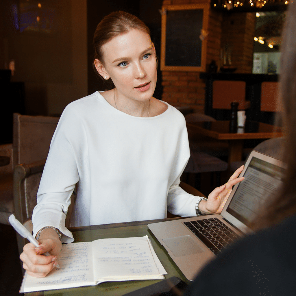 Interviewer taking notes during an interview, interviewee is just out of shot