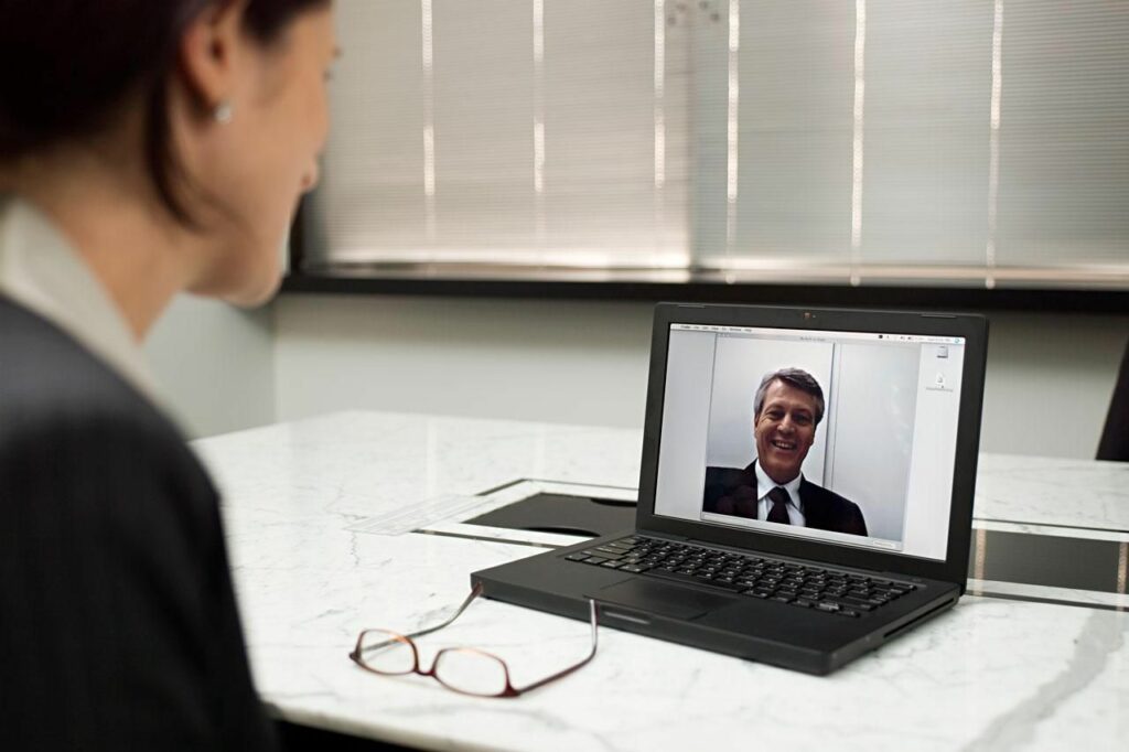 Business woman conducting remote interview on laptop