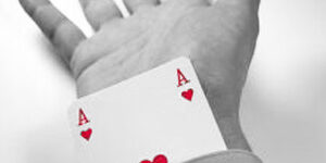 working with a recruiter to help your career An Ace of Hearts card protruding from the end of a business person's sleeve