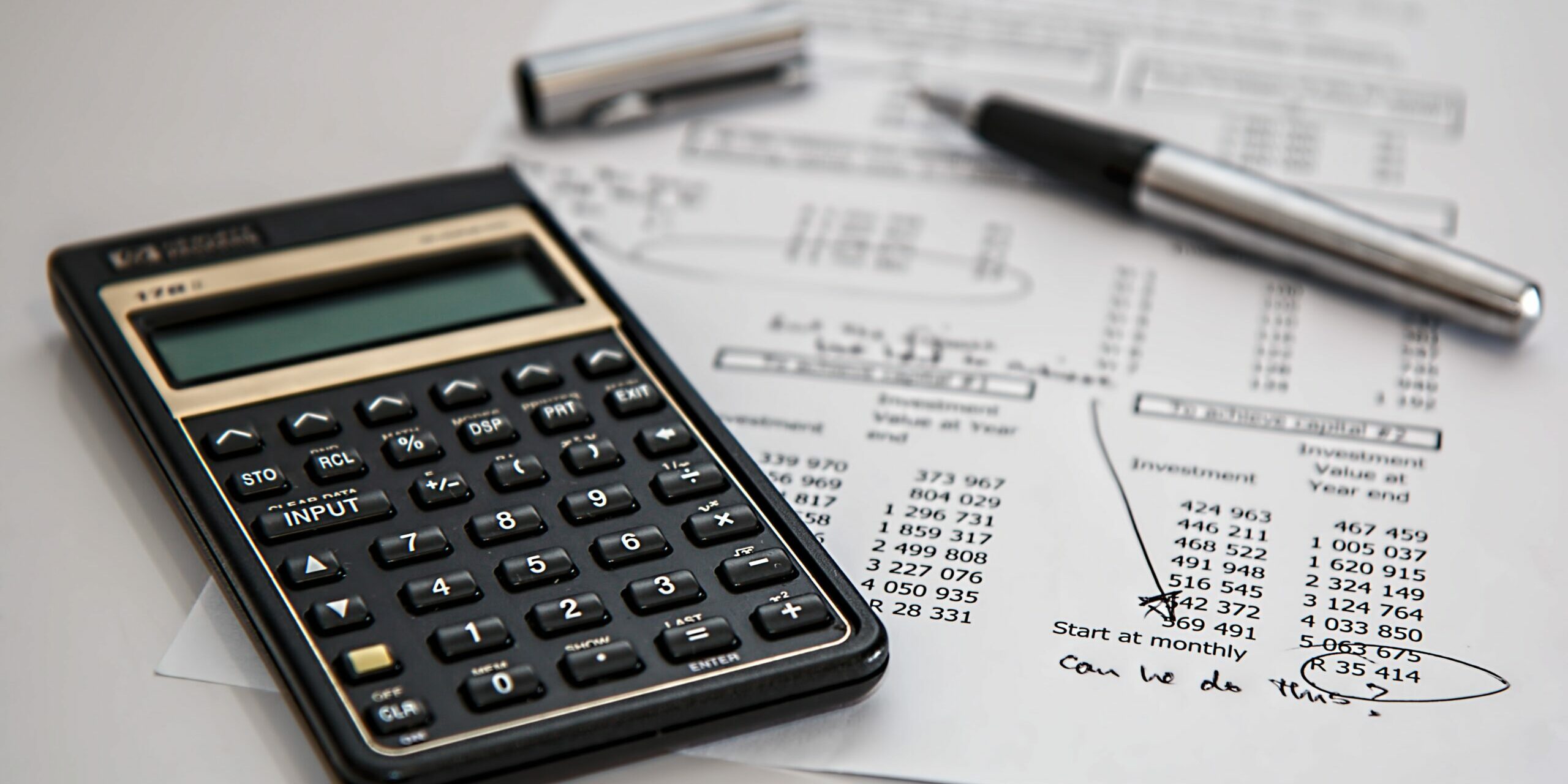calculator-calculation-insurance-finance-53621 Calculator on a desk with a page of financial information